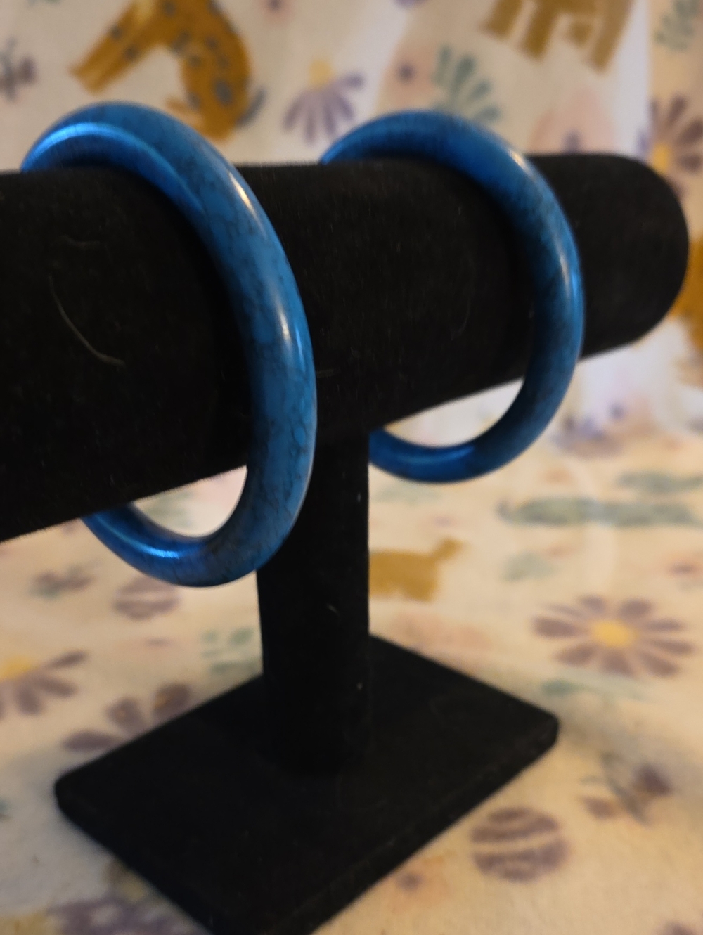 pair of smooth, rounded blue stone or resin bangle bracelets